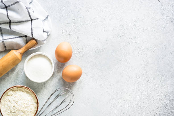 istock Baking background ingredients. Flour, sugar, eggs and rolling pin at light stone table. 2013326584