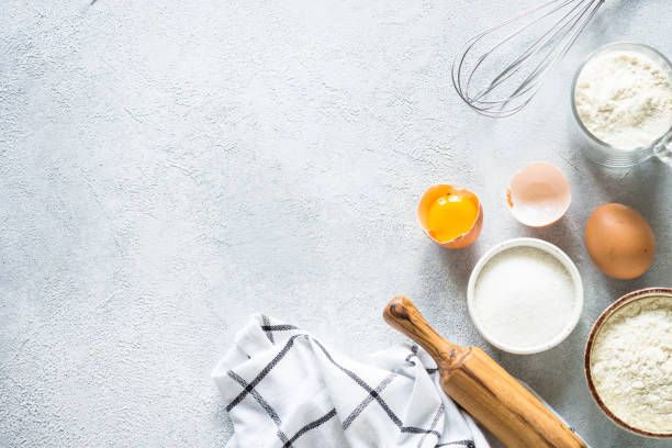 istock Baking background ingredients. Flour, sugar, eggs and rolling pin at light stone table. 2013326585