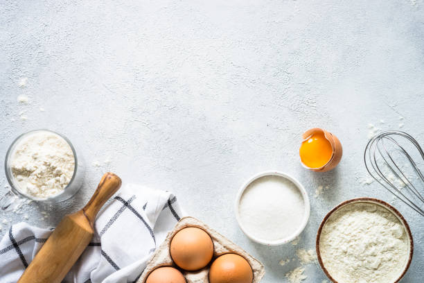 istock Baking background ingredients. Flour, sugar, eggs and rolling pin at light stone table. 2013327132