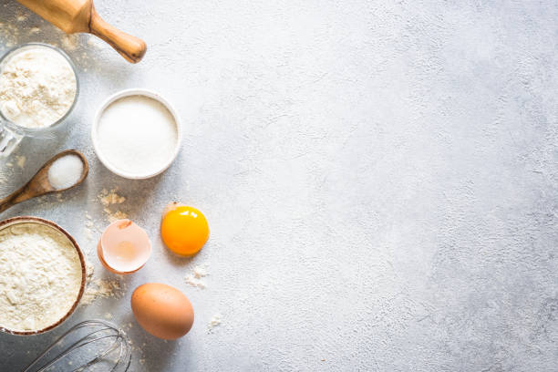 istock Baking background ingredients. Flour, sugar, eggs and rolling pin at light stone table. 2013327652