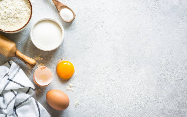 istock Baking background ingredients. Flour, sugar, eggs and rolling pin at light stone table. 2013327663