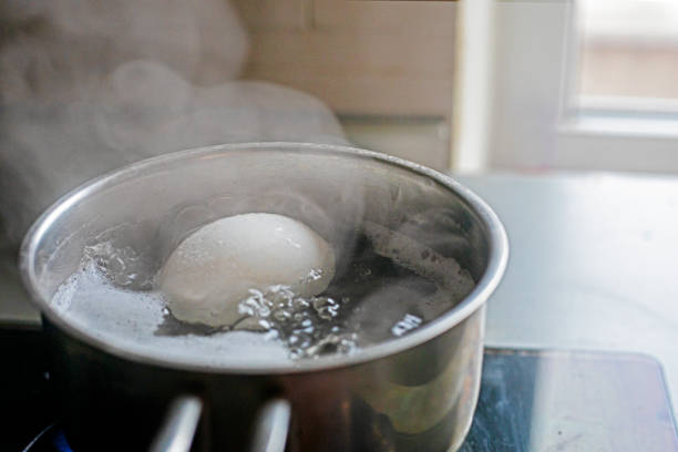 istock cook a chicken white egg in boiled water in a saucepan at home 2013346628