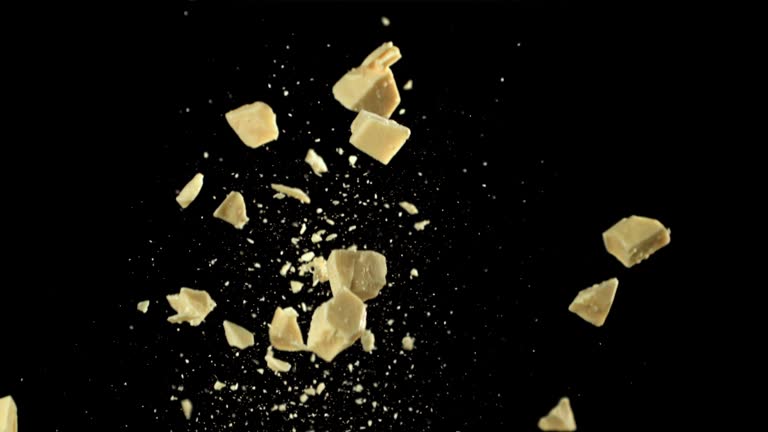 Pieces of white chocolate fly up and fall down. Filmed on a high-speed camera at 1000 fps.