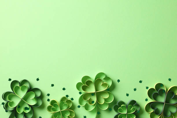 istock St Patrick's Day four leaf clover paper art on green background with confetti. Top view. Flat lay. 2013451575