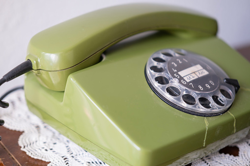 green Rotary Telephone with Disc Dial, Old Phone with Cracks, Connecting with Past, calls helpline, psychological support