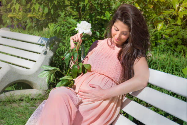 Pregnant woman reading a book in the park