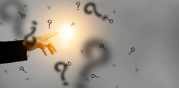 istock Idea concept. Hand touches an illuminated light bulb surrounded by black question marks. Lightblub is on as a symbol of innovation, inspiration, solution, and creativity. Creative ideas and thinking 2013510772