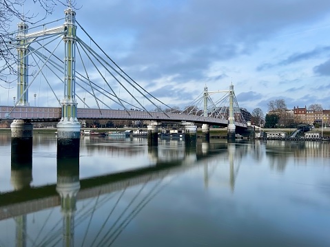 Albert Bridge in Chelsea London.  During the day with long exposure, water is smooth.  No people.  Taken from Battersea Park.