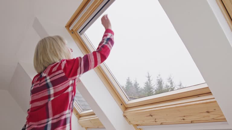 Woman closing heat conserving blinds