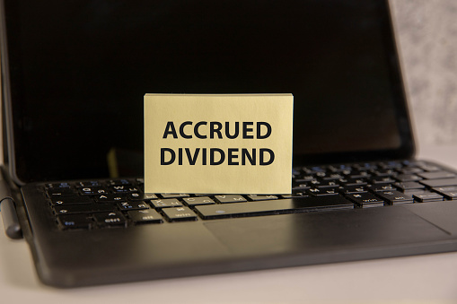 accrued DIVIDEND, text on a notepad on table, business concept.