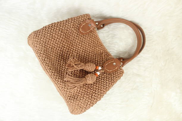 istock Knitted handmade milky brown bag on furry white blanket. Top view. 2013671270