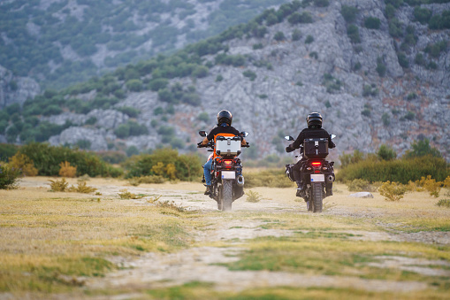 Two adventure touring motorcycle riders riding on the country road
