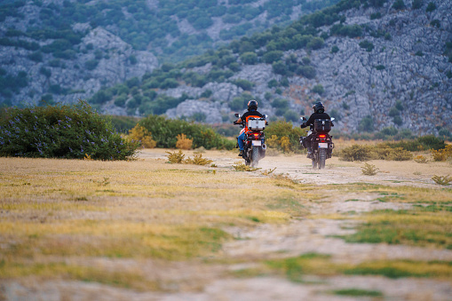 Two adventure touring motorcycle riders riding on the country road