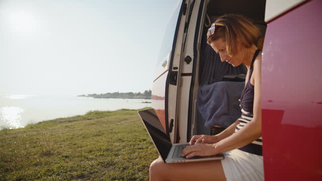 SLO MO Shot of Smiling Woman Using Laptop in Camping Van While Working Remotely