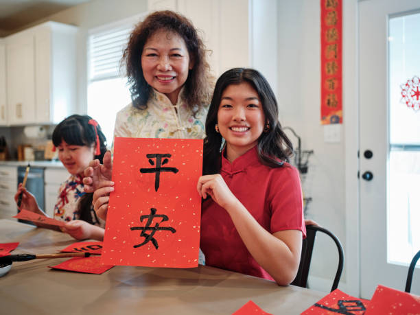 chinese family practicing calligraphy for chinese new year fai chun (auspicious messages) - chinese script text calligraphy grandmother stock-fotos und bilder