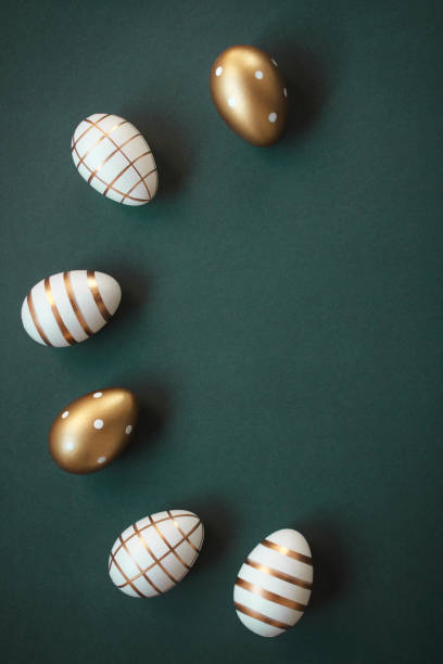 istock Elegant Easter eggs arranged in semi-circle decorated with gold on dark green background with copy space 2013752002