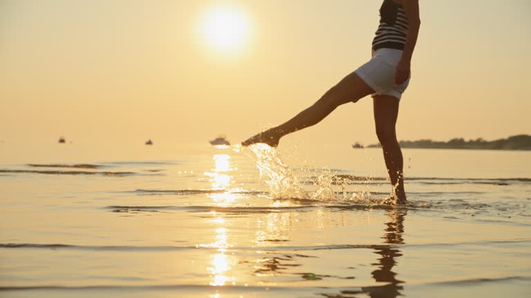 SLO MO Shot of Woman Walking on Shore at Tranquil Sunset Beach During Vacation