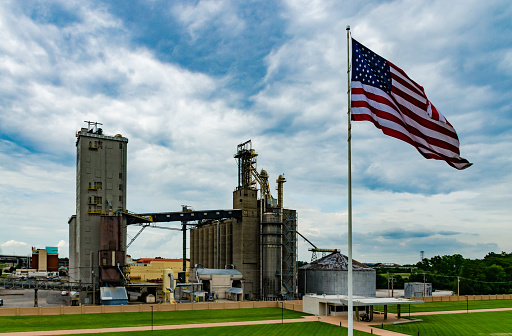 Missouri, USA - May 15, 2018: - American flag against the background of an industrial facility near the city of St. Louis in Missouri, USA