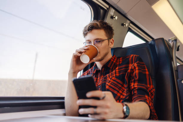 istock A young man is traveling by train, using his phone and typing on phone. 2013812056
