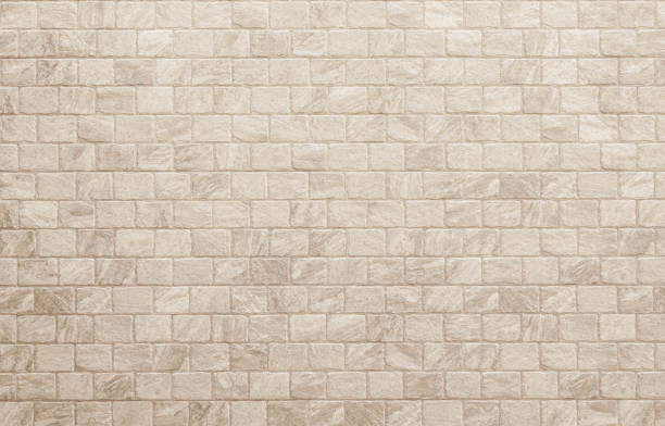 istock Empty background of wide cream brick wall texture. Beige old brown brick wall concrete or stone textured, wallpaper limestone abstract flooring. Grid uneven interior rock. Home decor design backdrop. 2013821019