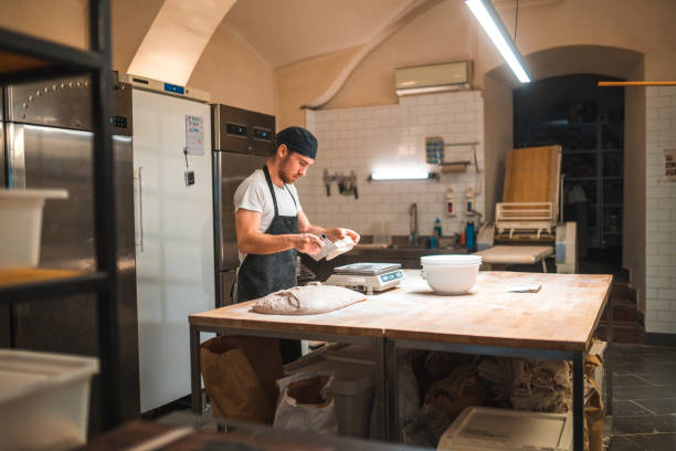 istock Caucasian Baker Weighting  Dough In A Small Bakery 2013826292
