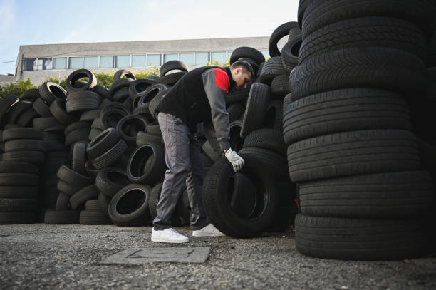 istock maintenance worker carrying tires outdoors. 2013850631