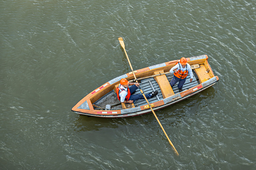 Panama Canal, Panama - July 24, 2023: Red helmet workers wait for ship cables in front of Pedro Miguel Locks, with rowing sloop. Birdseye view.