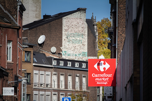 Picture of a sign with the logo of Carrefour market in front of their local store in downtown Liege, belgium. Carrefour market is a chain of proximity convenience stores created the Carrefour Group, a French multinational retailer. It is one of the largest hypermarket chains in the world