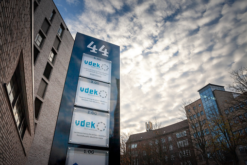 Picture of the sign of VDEK on their office in Dortmund. The vdek, or Verband der Ersatzkassen e.V., is an association of substitute health funds in Germany. It represents six major public health insurance providers, including Barmer, DAK-Gesundheit, and Techniker Krankenkasse. Vdek plays a significant role in shaping health policy, providing services to its members, and promoting cooperative efforts within the German healthcare system. It also focuses on self-governance with representatives elected by insured individuals and employers. Vdek's headquarters are in Berlin, with regional offices throughout Germany, including Westfalen-Lippe