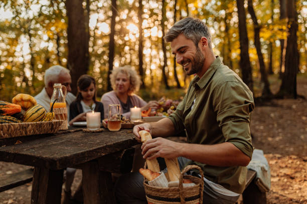 istock Father is breaking bread for his family during a picnic 2013932673