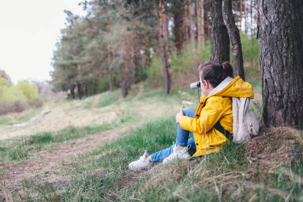 Little girl with binoculars in a beautiful forest glade