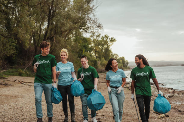 istock Five volunteers in uniforms walking and collecting trash by the river 2013962924
