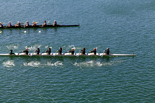 Cambridge, Massachusetts, USA - May 13, 2023: Overhead view of men rowing an eight man scull boat on the Charles River.