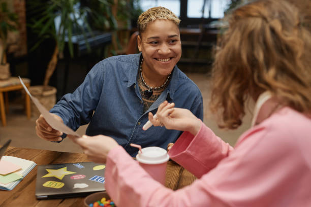 Smiling Black Woman Discussing Project with Colleague