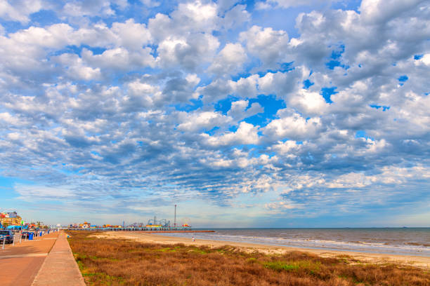 Seawall Drive along the beach in Galveston Texas with the famous Pleasure Pier in the distance.