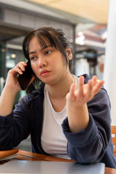 istock A stressed woman is talking on the phone, having a serious conversation with someone. 2014070854