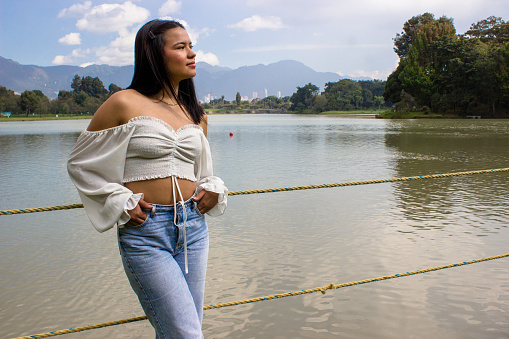 Beautiful young woman posing next to a lake