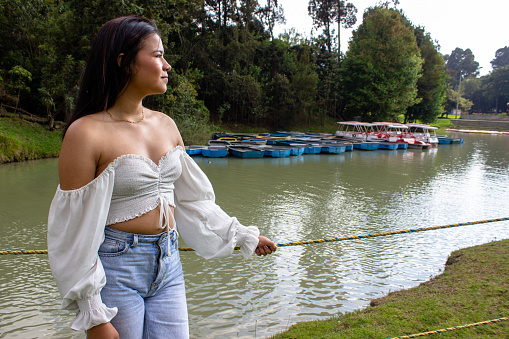 Beautiful young woman posing next to a lake