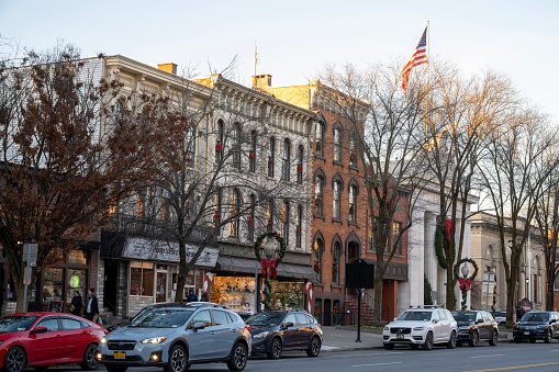 Saratoga Springs, USA - December 22, 2023. People walking on sidewalk in downtown Saratoga Springs, New York, USA