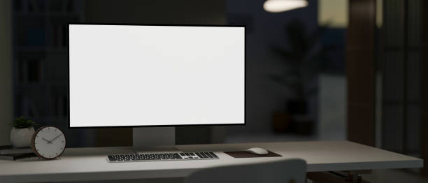 istock A PC computer white-screen mockup on a white desk in a modern dark office room at night. 2014100879