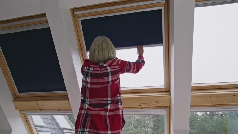 Woman closing heat conserving blinds