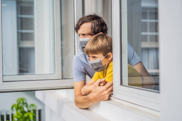 istock Extremly tired father and son looking out the window, home alone. self-isolation at home, quarantine due to pandemic COVID 19. Mental health problems in self-isolation at home, quarantine, isolation, stay at home 2014105930