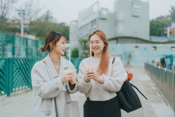 istock Two Asian young women walking outdoors and enjoying a conversation with each other, playing with some nostalgic toys in Hong Kong 2014121218