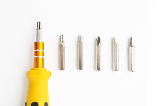 screwdriver and Set of heads for screwdriver (bits) on a white background. top view, copy space