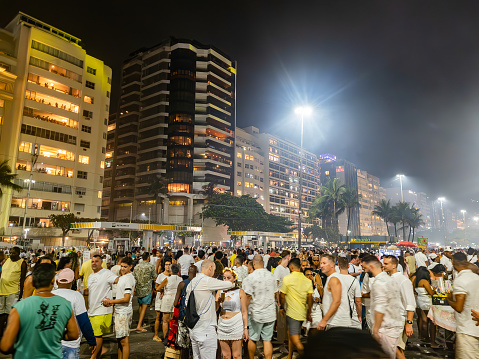 Crowd on the tiled sidewalk of Atlantica Avenue in Copacabana, Rio De Janerio, Brazil at night after the New Years Eve Fireworks