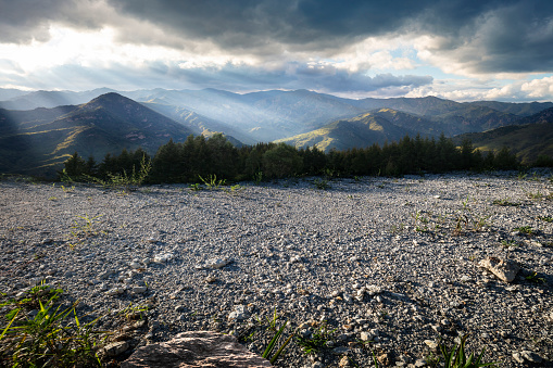 Under dramatic skies, rocky roads and natural mountains