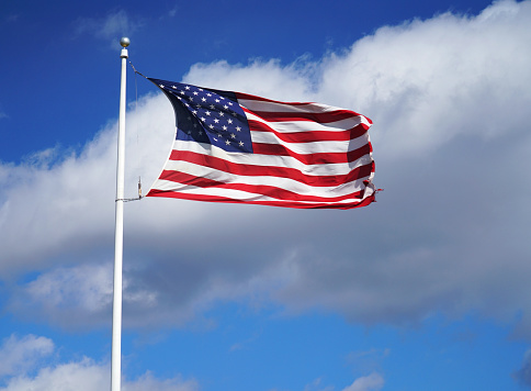waving USA flag on pole in sunny day
