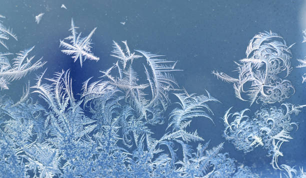 frost crystal on window glass in winter season - frosted glass glass textured crystal stock-fotos und bilder