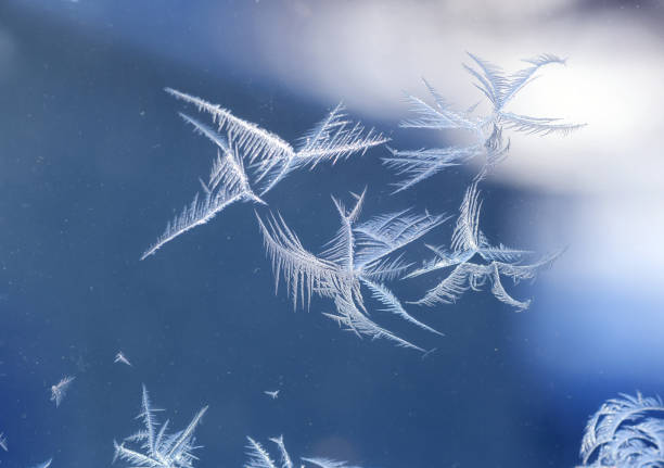 frost crystal on window glass in winter season - frosted glass glass textured crystal stock-fotos und bilder