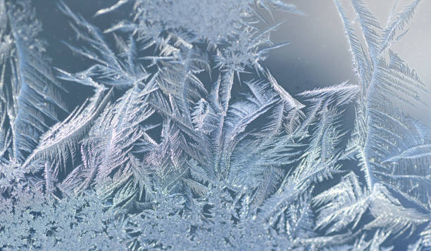 frost crystal on window glass in winter season - frosted glass glass textured crystal stock-fotos und bilder